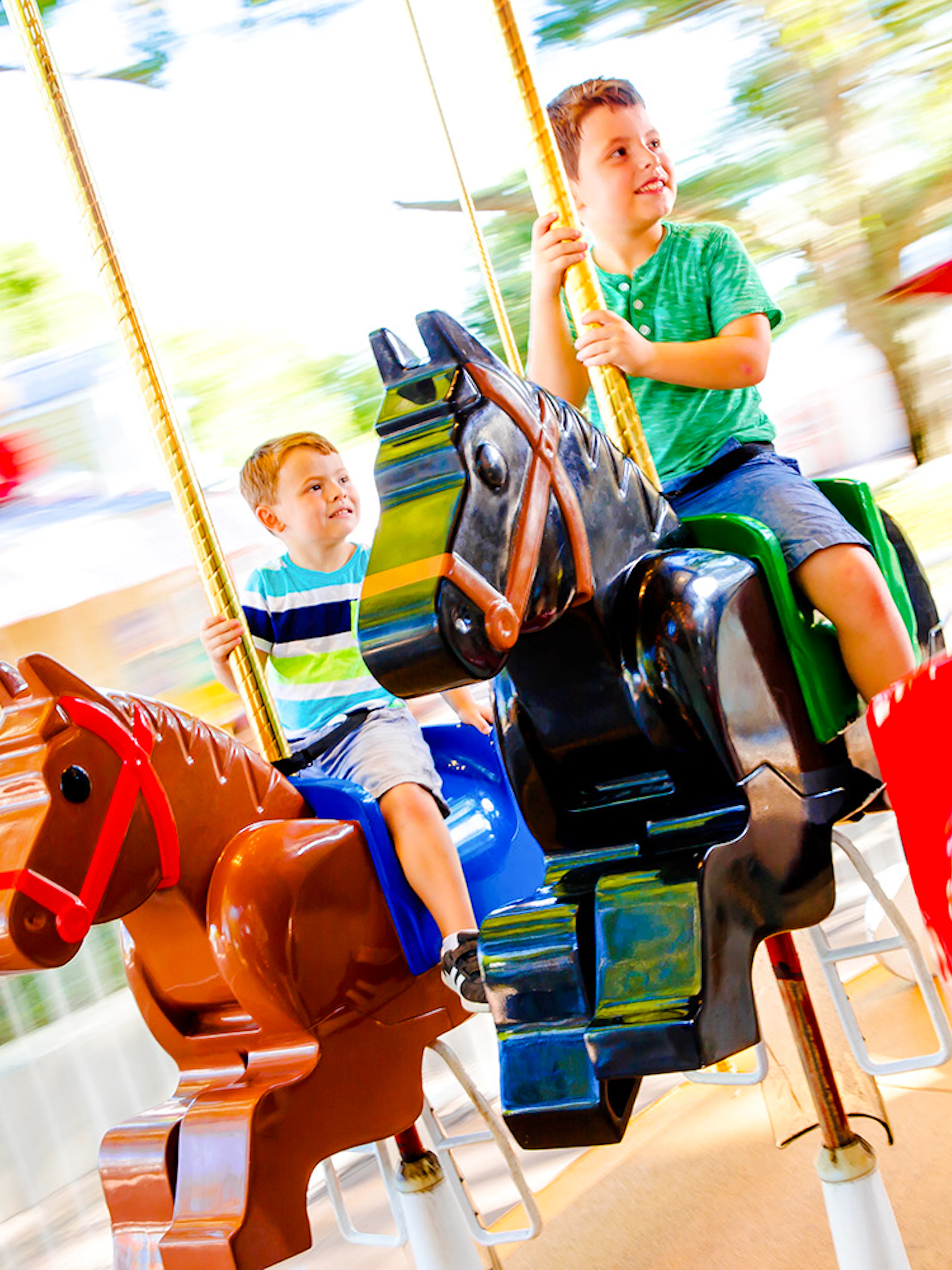 Children riding The Grand Carousel at Legoland Florida on colorful horse figures.