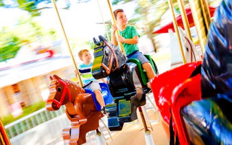 Children riding The Grand Carousel at Legoland Florida on colorful horse figures.