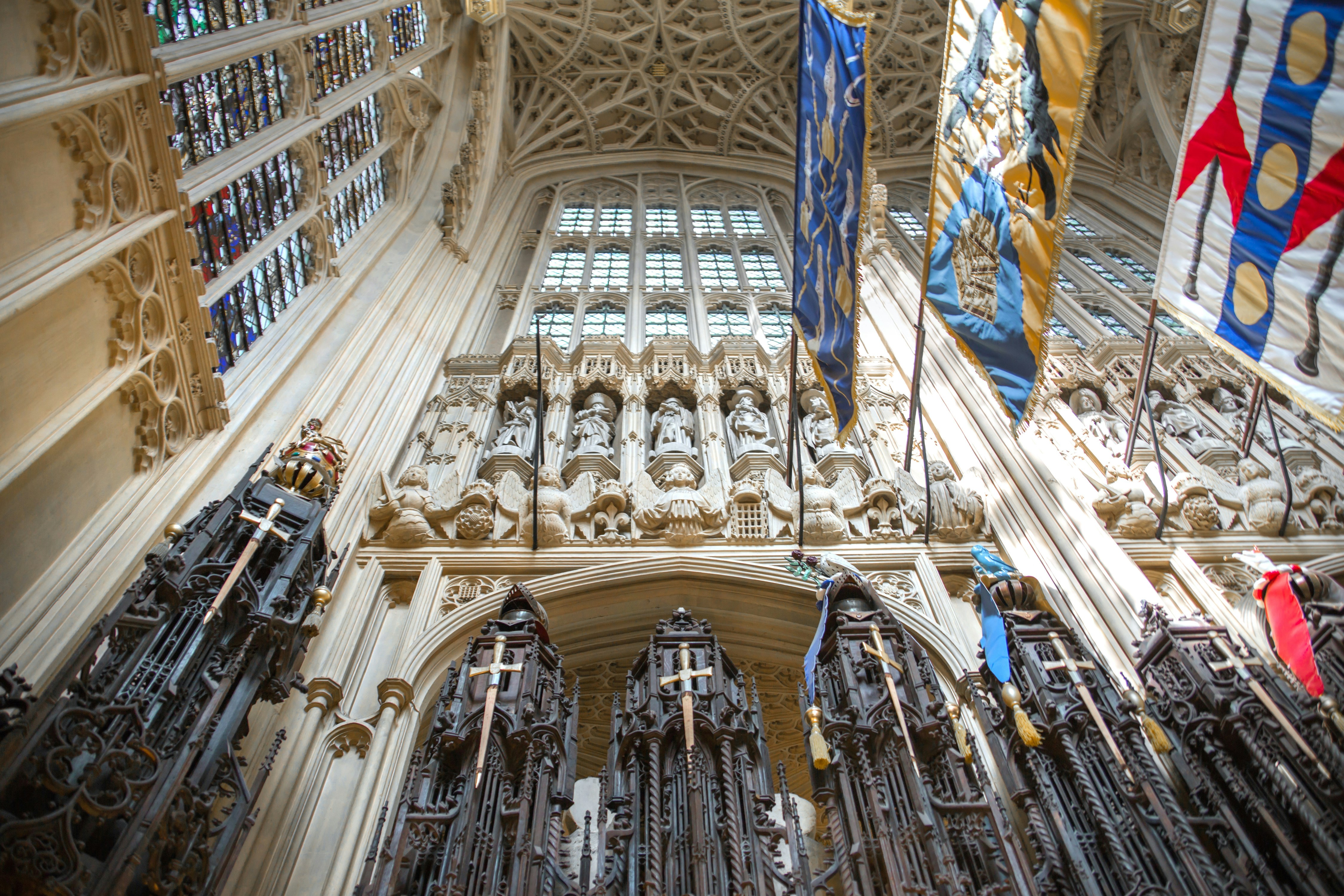 Choir stalls and knights’ banners in a historic cathedral interior.