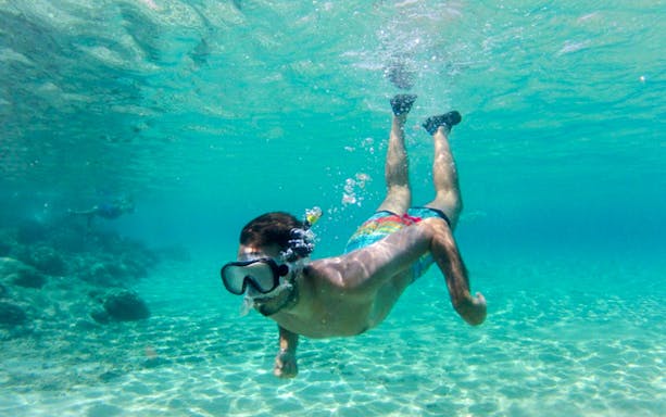 Snorkeler exploring clear waters in Chia during Cagliari 4x4 tour.