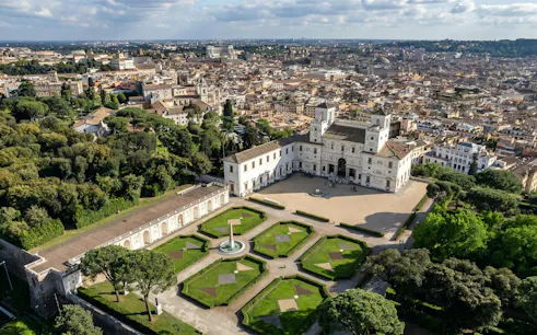Villa Medici in Rome with formal gardens and cityscape in the background.