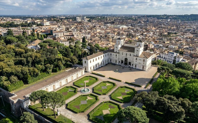 Villa Medici in Rome with formal gardens and cityscape in the background.