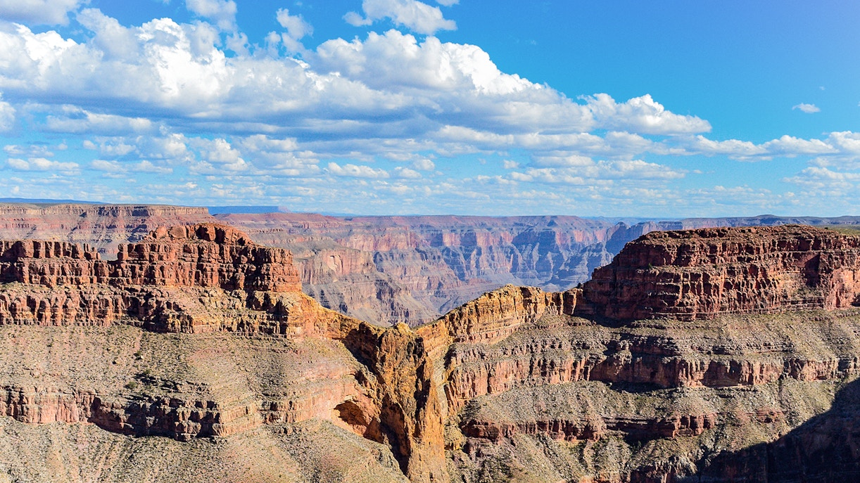 Helicopter landing at Grand Canyon Eagle Point during sunset with tourists enjoying a champagne picnic.