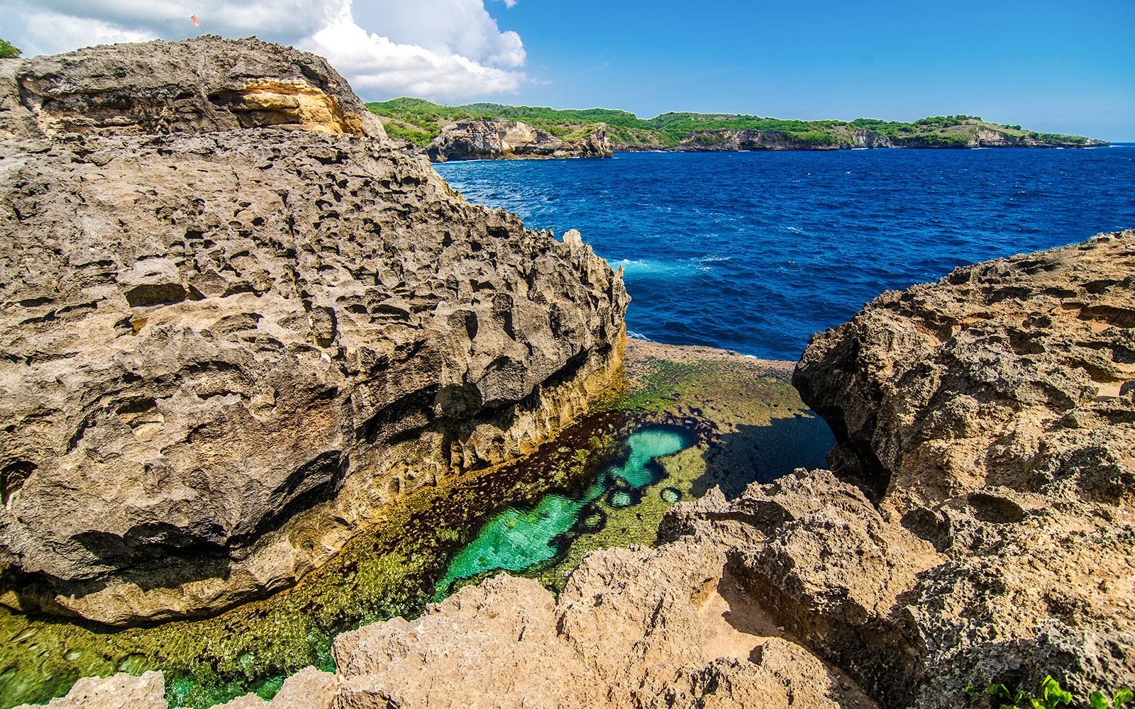 Rocky coastal view of Angel’s Billabong, Nusa Penida, with clear blue water and natural pool.