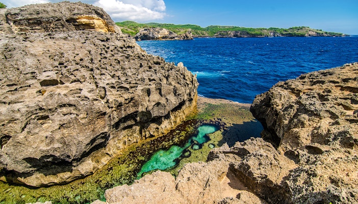 Rocky coastal view of Angel’s Billabong, Nusa Penida, with clear blue water and natural pool.