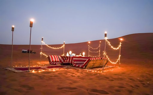 Desert dining setup with cushions and lights for Dubai private luxury family dinner.