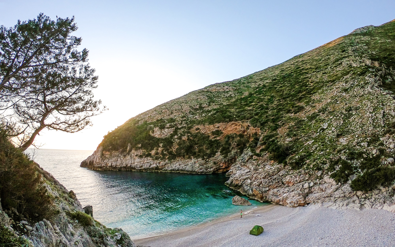 Secluded beach with turquoise waters and rocky cliffs on the Blue Caves Albania tour.