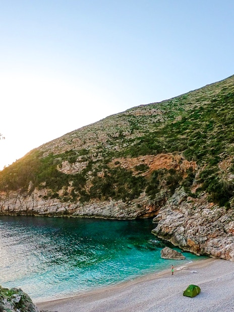 Secluded beach with turquoise waters and rocky cliffs on the Blue Caves Albania tour.