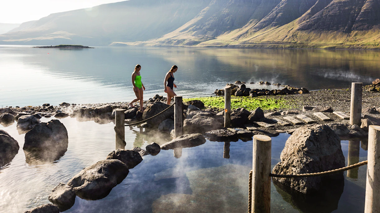 Visitors enjoying Hvammsvík Hot Spring with scenic mountain views near Reykjavík.