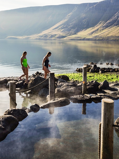 Visitors enjoying Hvammsvík Hot Spring with scenic mountain views near Reykjavík.