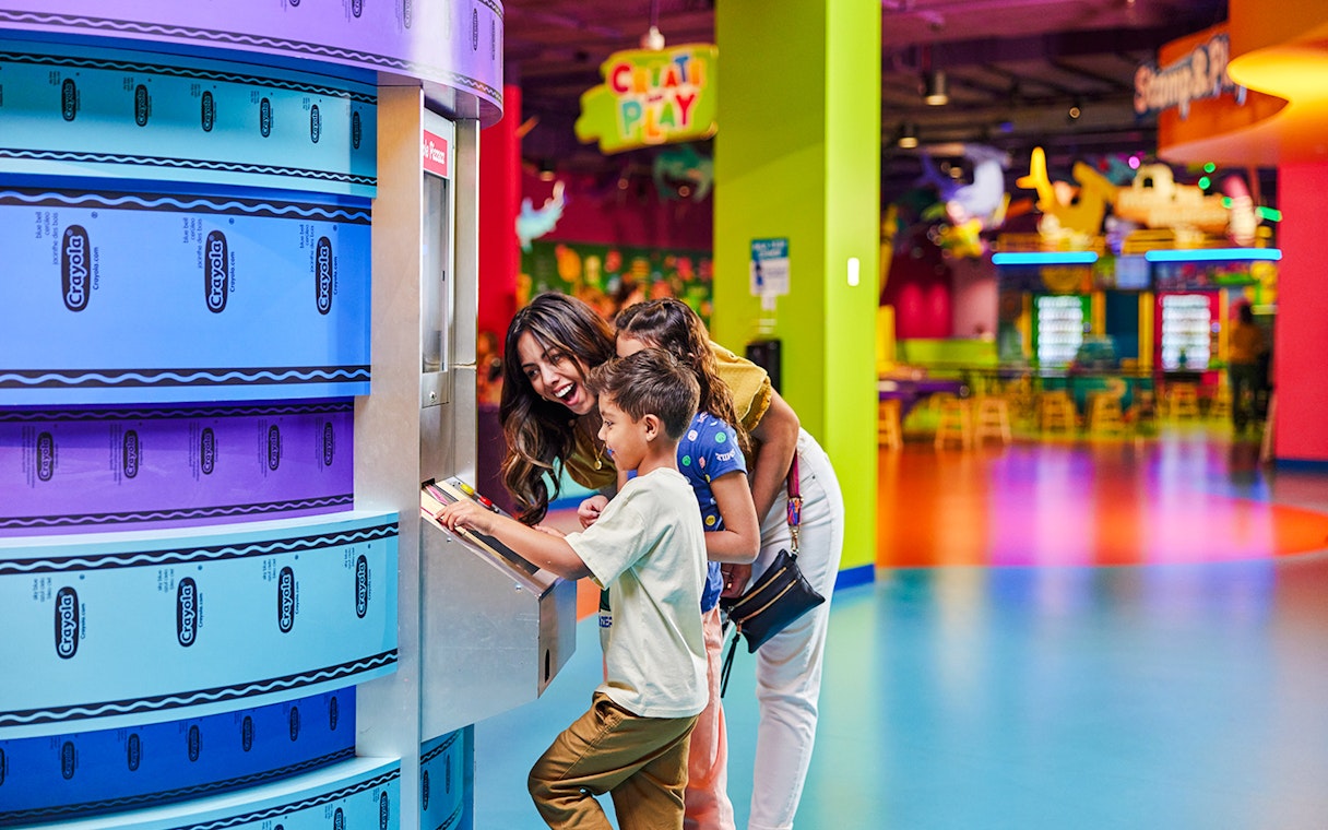 Family using Crayola Crayon maker at Crayola Experience, Mall of America.