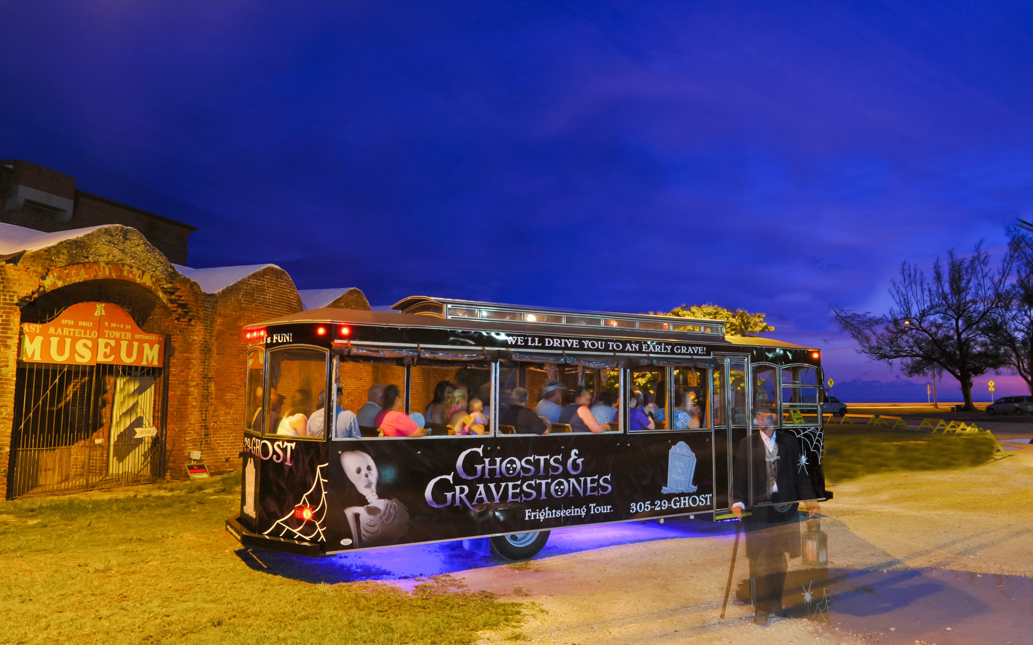 Ghosts & Gravestones tour trolley at East Martello Museum during evening.