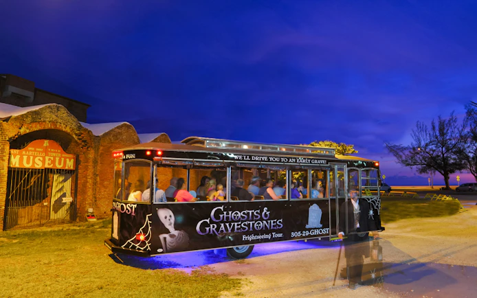 Ghosts & Gravestones tour trolley at East Martello Museum during evening.