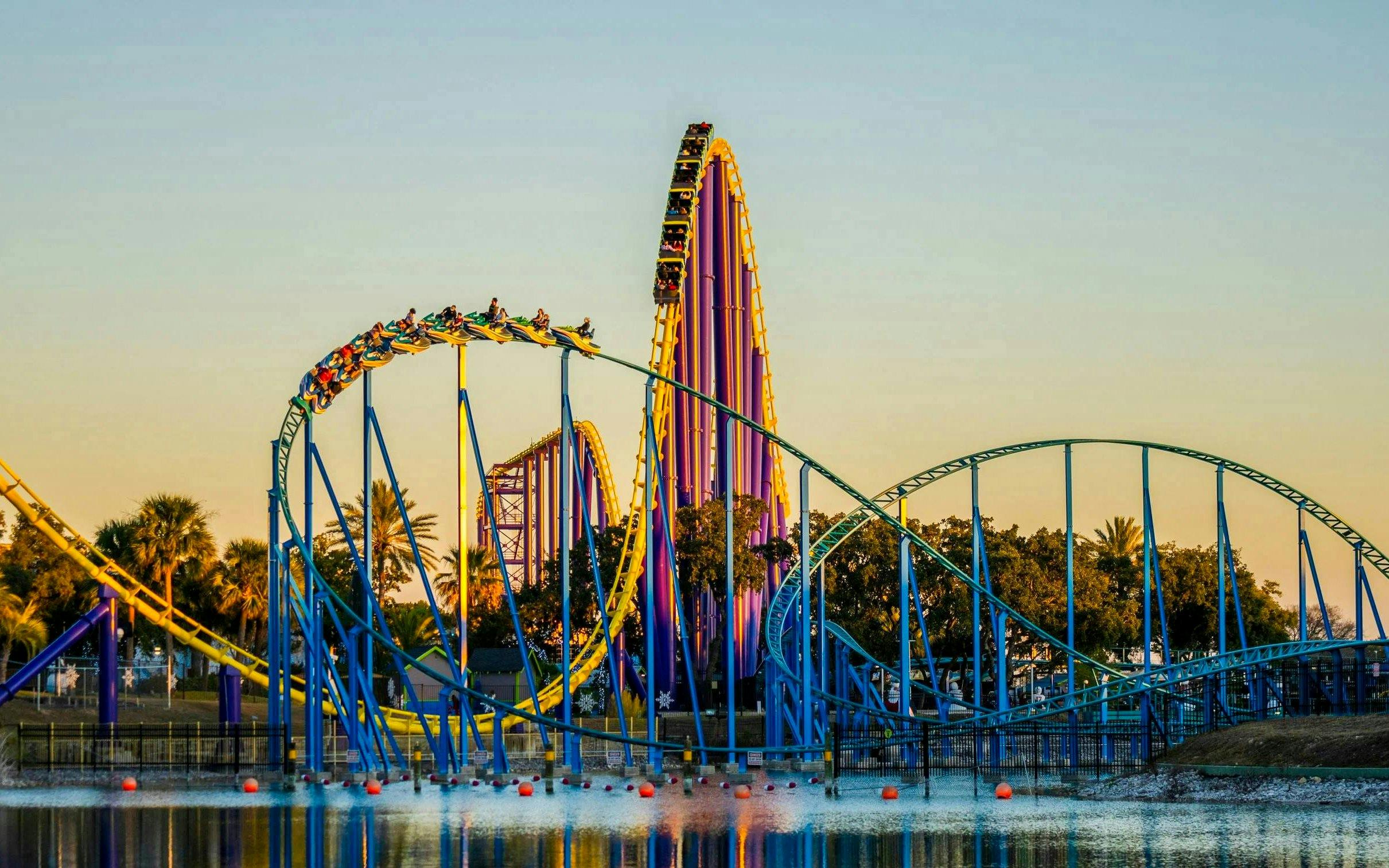 Roller coaster at SeaWorld San Antonio with vibrant loops and tracks over water.