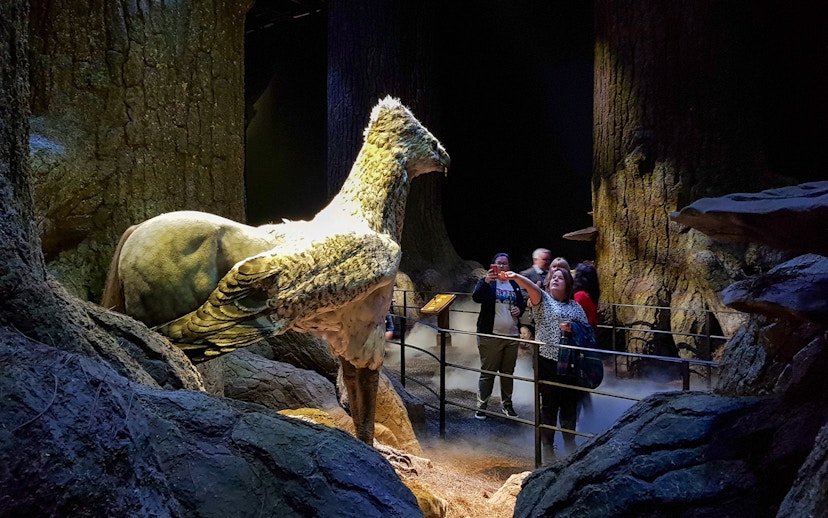 Visitors at Harry Potter Studios with Buckbeak model, London film location tour.
