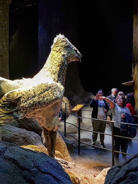 Visitors at Harry Potter Studios with Buckbeak model, London film location tour.