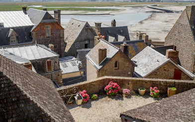 Slate-roofed houses in Mont Saint-Michel with a view of the tidal flats.