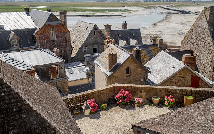 Slate-roofed houses in Mont Saint-Michel with a view of the tidal flats.