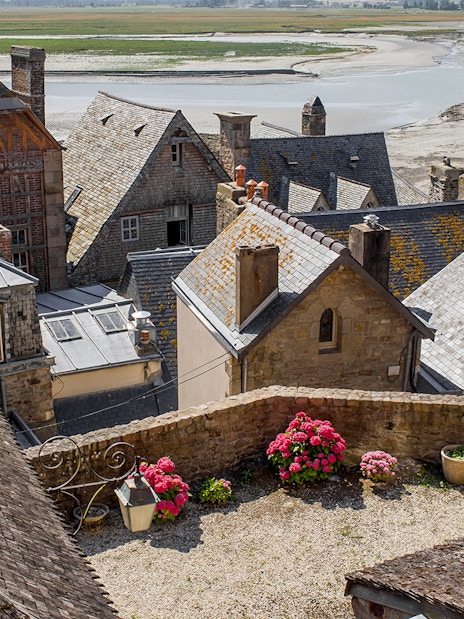 Slate-roofed houses in Mont Saint-Michel with a view of the tidal flats.