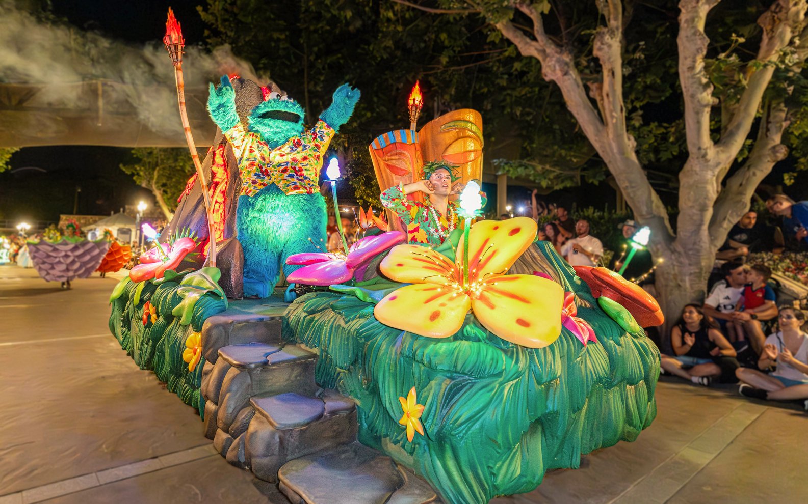 Parade float with colorful flowers and characters at PortAventura World.