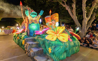 Parade float with colorful flowers and characters at PortAventura World.