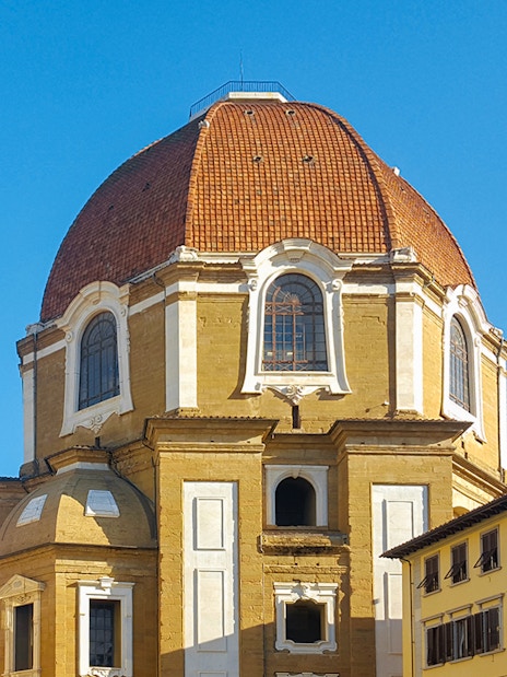 Cappelle Medicee dome and exterior in Florence, Italy, with surrounding buildings.