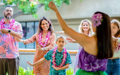 Guests learning hula dance from instructor before Rock-A-Hula show in Hawaii.