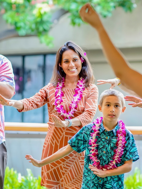 Guests learning hula dance from instructor before Rock-A-Hula show in Hawaii.