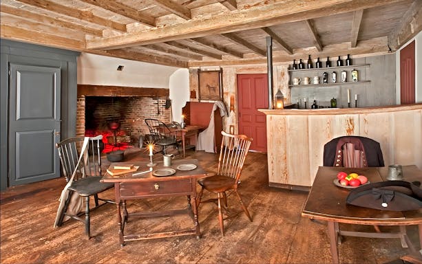 Interior of Buckman Tavern in Boston with colonial-era furnishings and fireplace.