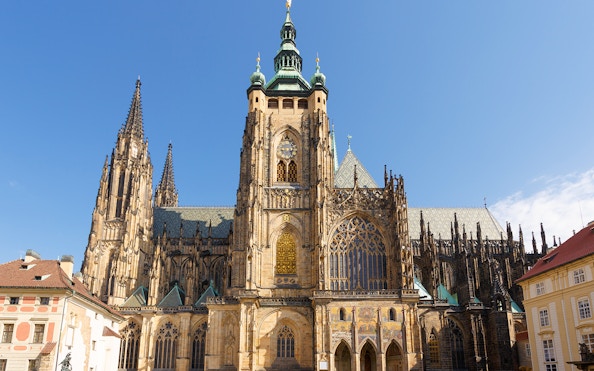 Prague Castle with Gothic architecture under a clear blue sky.