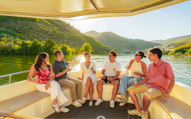 Tourists enjoying a boat ride on the Douro River in Douro Valley at sunset.