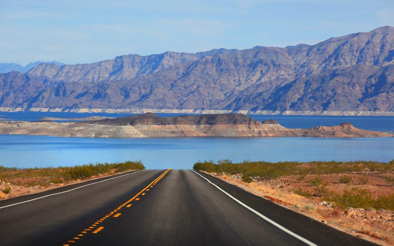 Desert road leading to Lake Mead with mountains in the background near Las Vegas.