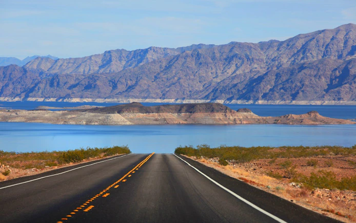 Desert road leading to Lake Mead with mountains in the background near Las Vegas.
