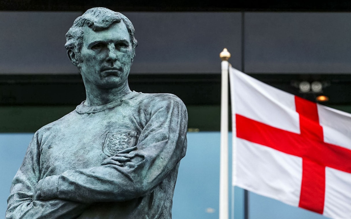 Statue of Bobby Moore with England flag at Wembley Stadium.