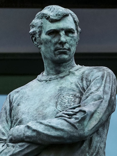 Statue of Bobby Moore with England flag at Wembley Stadium.