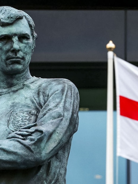 Statue of Bobby Moore with England flag at Wembley Stadium.