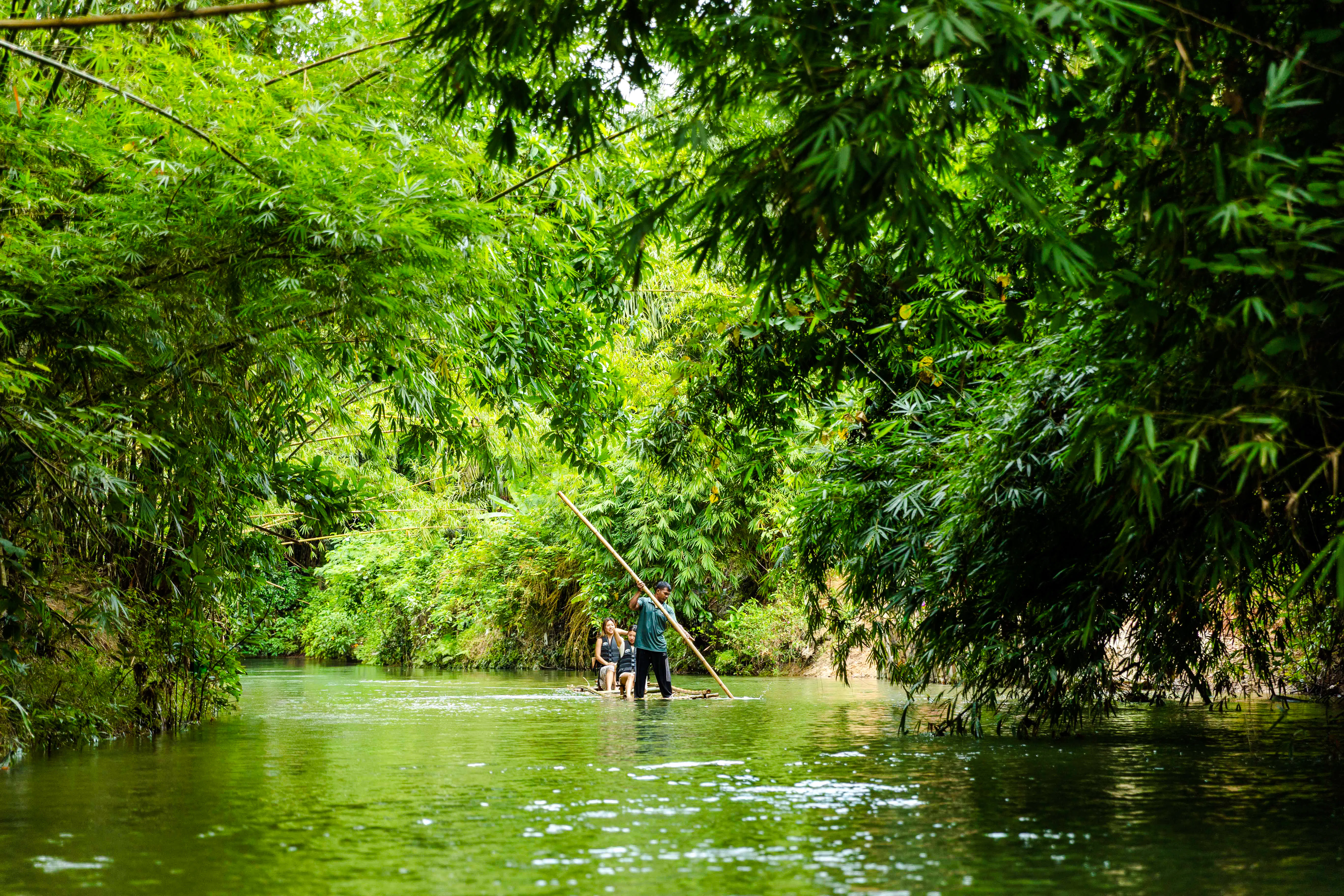 Bamboo rafting through lush greenery in Phuket, part of the Sky Rock Khao Lak adventure tour.