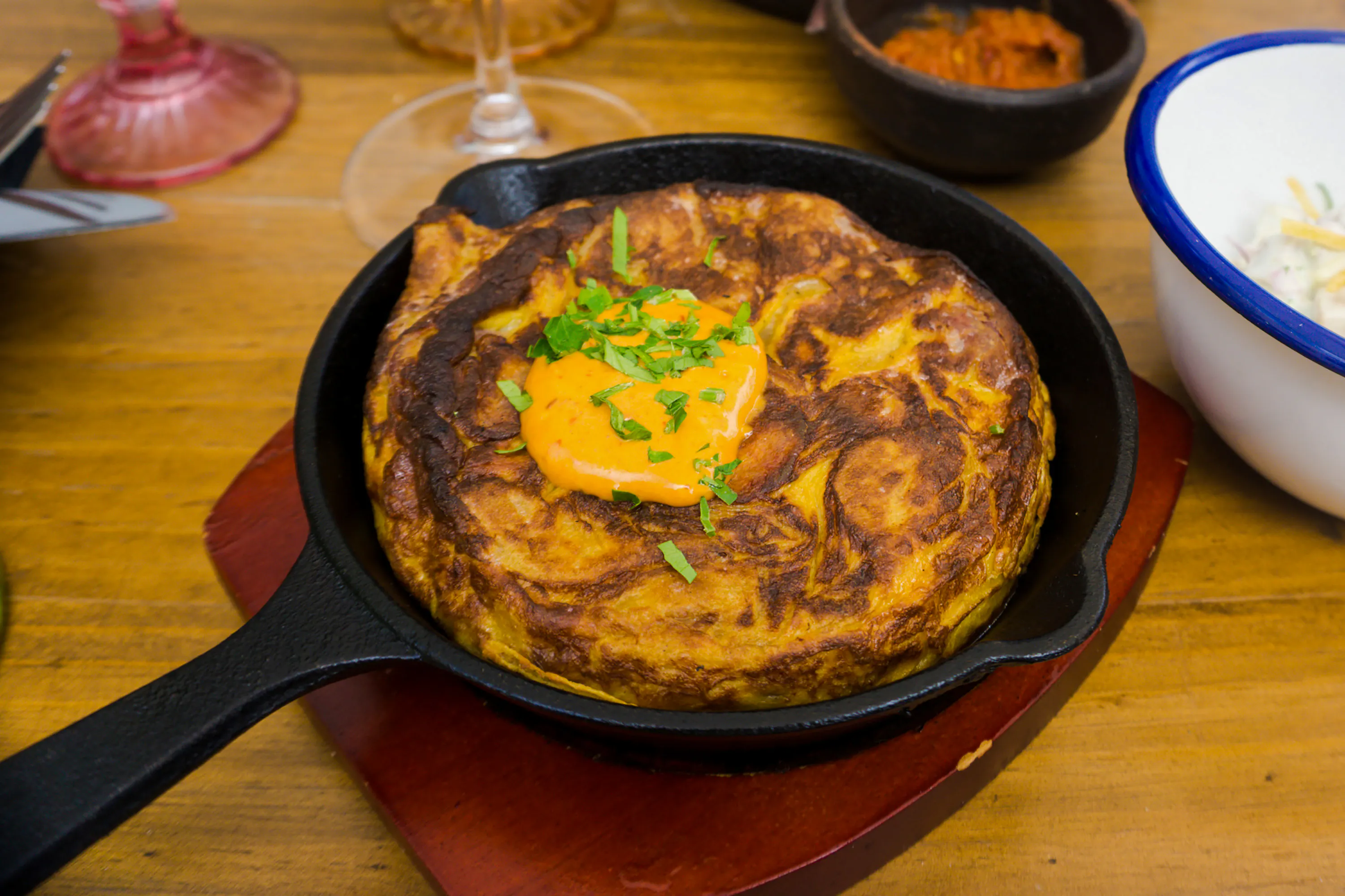 Traditional Spanish tortilla with sauce in a skillet at a Santiago restaurant.