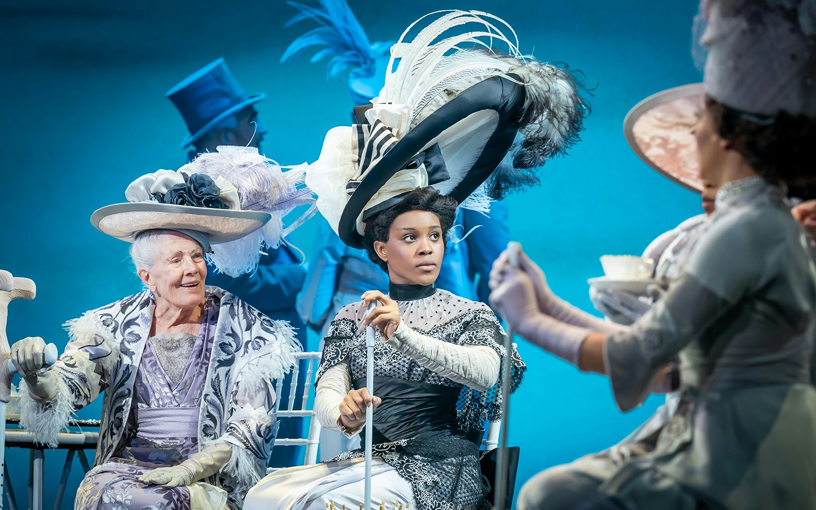 Actors in period costumes performing a scene from "My Fair Lady" on stage.