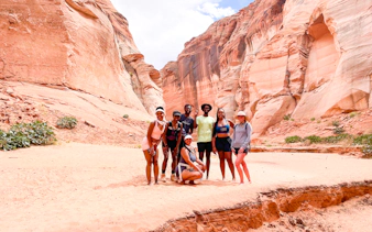 Group of hikers in Antelope Canyon, Page, surrounded by red rock formations.