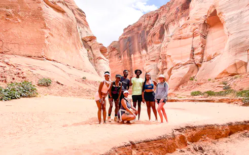 Group of hikers in Antelope Canyon, Page, surrounded by red rock formations.
