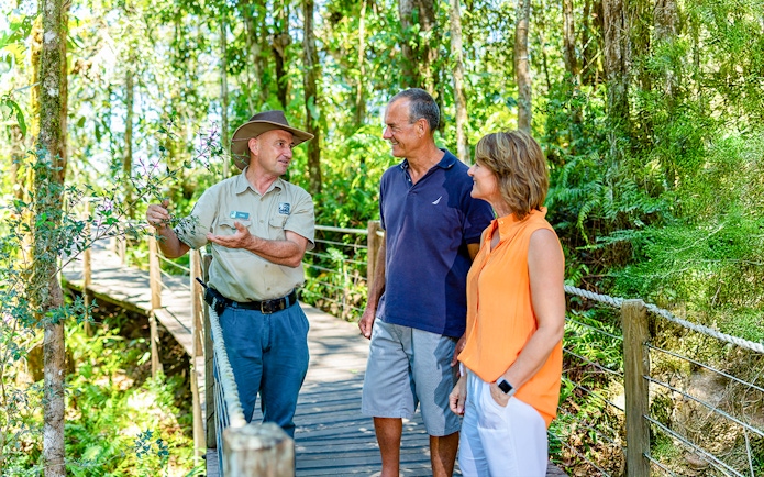 Guide explaining rainforest plants to tourists on Kuranda tour from Cairns.