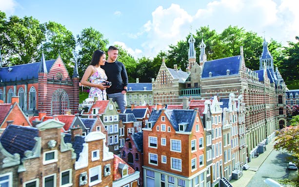 Couple exploring miniature Dutch buildings at Kinderdijk UNESCO World Heritage site.
