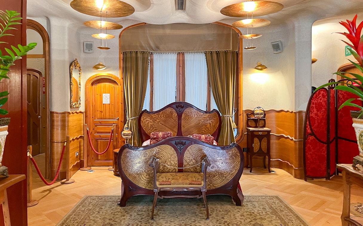 Casa Batlló bedroom with ornate wooden bed and decorative furnishings in Barcelona.