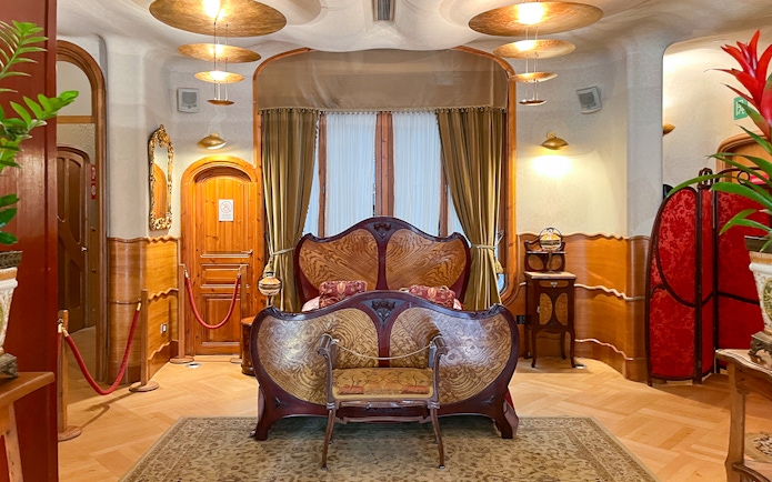 Casa Batlló bedroom with ornate wooden bed and decorative furnishings in Barcelona.
