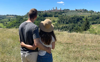 Couple enjoying view of San Gimignano during Tuscany Tuk Tuk tour.