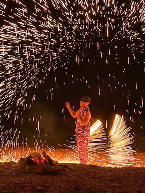 Performer with fire sparks at night show, Marrakesh desert camping Agafay.