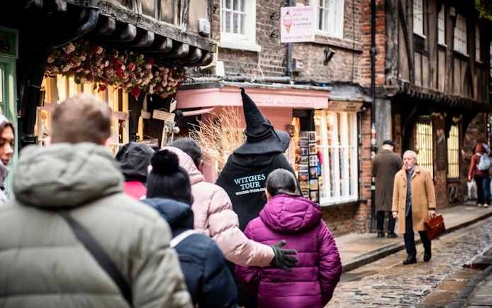 Group on York Witches & History Old Town Walking Tour with guide in witch hat.
