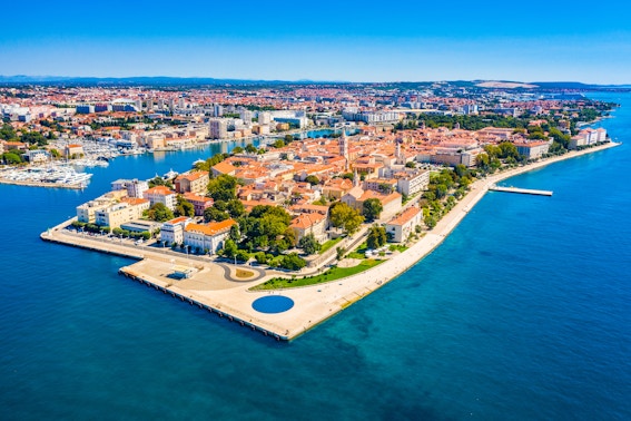 Aerial view of Zadar's Old Town peninsula, Croatia, surrounded by blue Adriatic Sea.