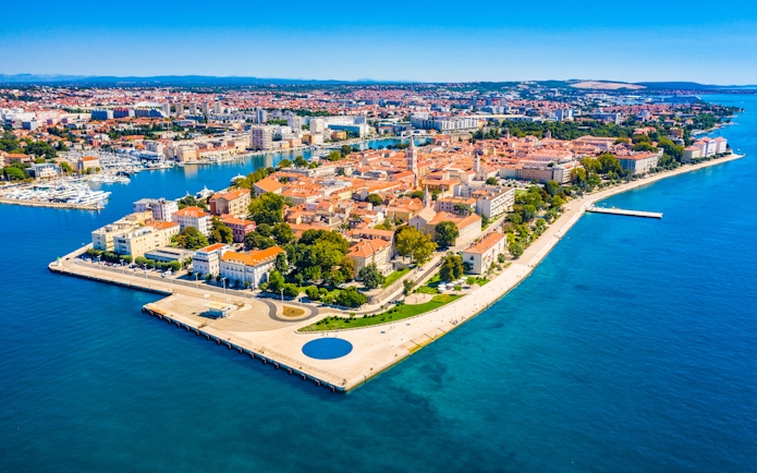 Aerial view of Zadar's Old Town peninsula, Croatia, surrounded by blue Adriatic Sea.